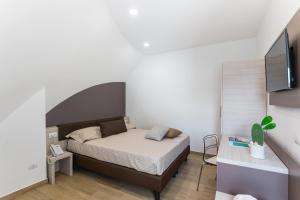 a small bedroom with a bed and a tv at Torre Cintola Greenblu Sea Emotions in Monopoli