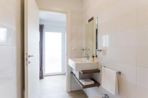 a white bathroom with a sink and a mirror at Torre Cintola Greenblu Sea Emotions in Monopoli