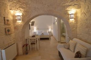 - un salon avec un canapé et un lit dans une chambre dans l'établissement La Corticella Bed & Breakfast, à Martina Franca