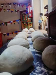 a row of uncooked pizzas are lined up on a table at Giramundo Hostel in Humahuaca