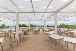 uma cafetaria vazia com mesas e cadeiras num telhado em Torre Cintola Greenblu Sea Emotions em Monopoli