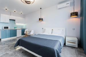 a bedroom with a blue bed and a kitchen at Апартаменти Герцена 35 in Kyiv