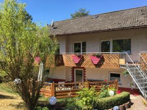 a house with a porch and a deck at Ferienwohnung Caroline in Hemfurth-Edersee
