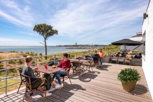 
people sitting at a picnic table at Stayokay Hostel Terschelling in West-Terschelling
