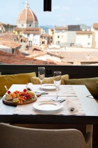 un tavolo con un piatto di bicchieri da cibo e vino di Hotel degli Orafi a Firenze