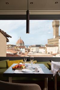 
a table with a glass of wine and a plate of food at Hotel degli Orafi in Florence
