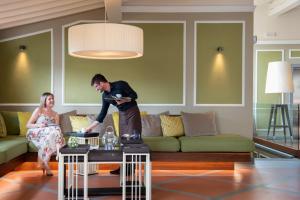 a man standing on a table in a living room with a woman at Hotel degli Orafi in Florence