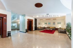 un grand salon avec des canapés et un tapis rouge dans l'établissement Duomo Deluxe Room, à Milan