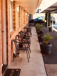 a row of chairs on the side of a building at Alfa motel in Gilgandra