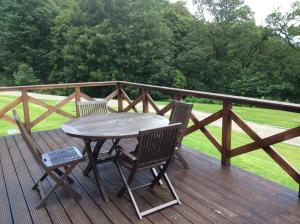 una mesa de madera y 2 sillas en una terraza en Keepers Cottage, en Dunkeld