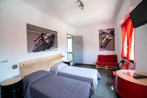 um quarto com 2 camas, uma televisão e um sofá em Italian Piston House Sport Moto Rent em Millesimo