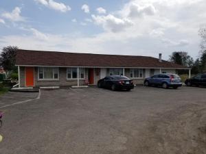 un edificio con dos coches estacionados en un estacionamiento en Eastwood Motel, en Woodstock