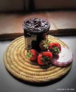 a basket with a jar of jam and strawberries on it at Maison Saint-Pé (Gers) in Béraut