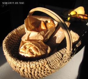 a basket filled with bread and other items on a table at Maison Saint-Pé (Gers) in Béraut