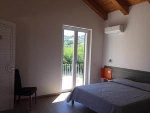 a bedroom with a bed and a large window at LE TORRI DEL CILENTO in Santa Maria di Castellabate