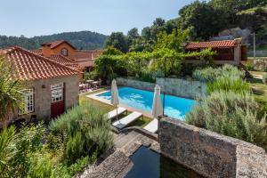 a villa with a swimming pool and a house at Casa do Eido - sustainable living & nature experiences in Valdosende