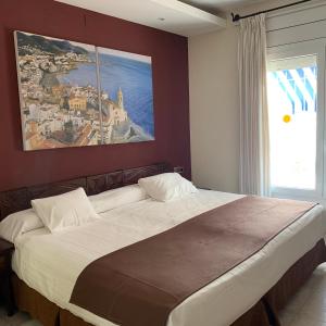 a bed sitting in a room next to a window at Galeón in Sitges