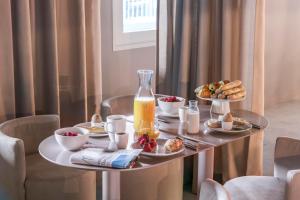 a table with breakfast foods and a bottle of orange juice at OKKO Hotels Paris Gare de l'Est in Paris
