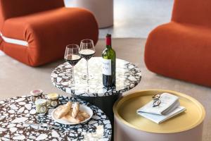 a table with a bottle of wine and two glasses at OKKO Hotels Paris Gare de l'Est in Paris