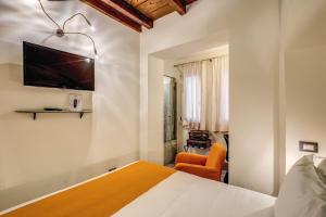 a bedroom with a bed and a tv on the wall at Casa Argileto in Rome