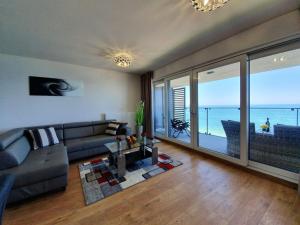 uma sala de estar com um sofá e vista para o oceano em Sailor- Z WIDOKIEM NA MORZE- 365PAM em Ustronie Morskie