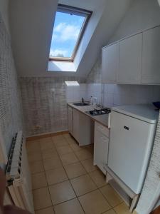 a kitchen with a skylight and a sink and a stove at Ravnice Rooms and Apartments in Zagreb