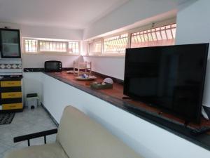 een woonkamer met een grote flatscreen-tv bij Fata dell'Etna in Pedara