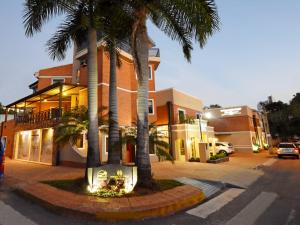 a building with palm trees in front of a street at Posada del Cielo in Asuncion