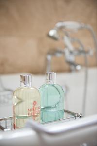 two bottles of soap sitting on a sink at Plumber Manor Hotel in Sturminster Newton
