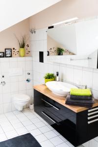 a bathroom with a sink and a toilet at Ferienwohnung Ausblick in Aßlar