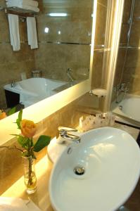 baño con lavabo y jarrón con flor en Regency Palace Hotel en Jounieh