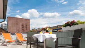 a patio with a table and chairs on a roof at Hotel Plaza in Frankfurt/Main