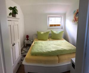 a bedroom with two beds with green pillows at Sommerhaus Boldevitz auf Rügen in Boldevitz