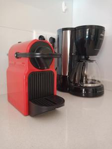 a red toaster sitting on a counter next to a coffee maker at La Nara Villa in Ferreira do Zêzere