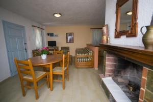 a dining room with a table and chairs and a fireplace at Gialos Studios & Apartments in Ierapetra