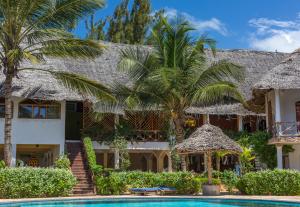 una casa con piscina y palmeras en AHG Waridi Beach Resort & SPA en Pwani Mchangani