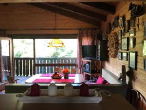 a dining room with a table and a balcony at Günther's Almhüttn in Arriach