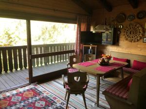 a living room with a table and a balcony at Günther's Almhüttn in Arriach