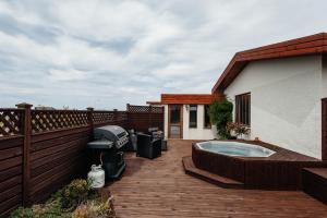 a deck with a hot tub on top of a house at Comfort and Rest in Sandgerði