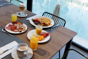 two plates of breakfast food on a table with drinks at Hotel Paradiso Garden in Playa de Palma