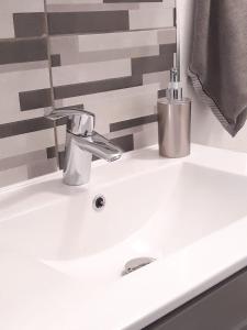 un lavandino bianco del bagno con rubinetto di Comfort Stay Basel Airport 1A46 a Saint-Louis