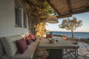 a patio with a couch and a table and the ocean at Elayio Houses in Kardiani