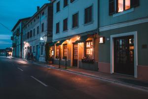 una strada cittadina vuota di notte con edifici di Apartments Pri Mari a Piran