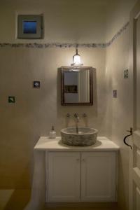 a bathroom with a sink and a mirror at Elayio Houses in Kardiani