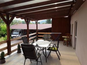 un patio con mesa y sillas en una terraza en Mária Vendégház, en Bogács