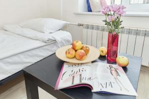a table with a plate of fruit and a book at Alisa Guest House in Saint Petersburg
