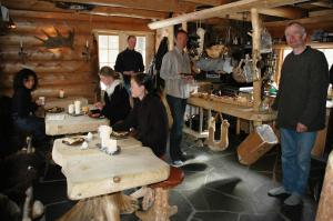 grupa osób stojących w pokoju z drewnianymi stołami w obiekcie Engholm Husky Design Lodge w mieście Karasjok