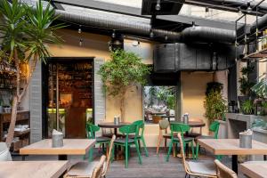 een restaurant met tafels, stoelen en planten bij WYNWOOD Hotel in Sint-Petersburg