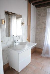 a white bathroom with a sink and a mirror at Gîte Design in Arceau