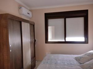 sypialnia z łóżkiem i oknem w obiekcie Ap da Cris w mieście Torres